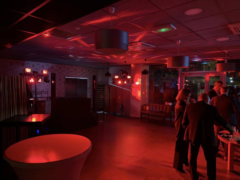 Ambiance élégante et festive lors d'une soirée d'entreprise à l'hôtel Appart'City Caluire, animée par GR-EVENEMENT avec une mise en lumière rouge et un DJ set professionnel près de Lyon.